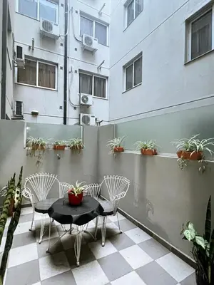 a patio with a table and chairs and a building at Dpto 1 dormitorio céntrico piscina cochera in Villa Carlos Paz