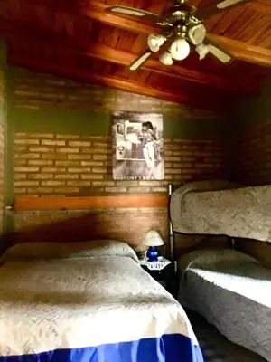 a bedroom with two beds and a ceiling fan at ovidio and Elda's house in Villa Carlos Paz