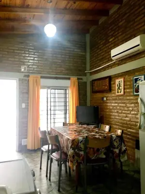 a dining room with a table and chairs and a window at ovidio and Elda's house in Villa Carlos Paz