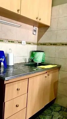 a kitchen counter with a sink and a green container at ovidio and Elda's house in Villa Carlos Paz