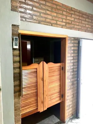 an open wooden door in a brick wall at ovidio and Elda's house in Villa Carlos Paz