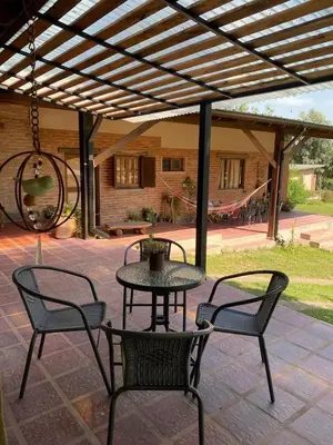 a patio with a table and two chairs and a swing at Ataias 2 in Santa Rosa de Calamuchita