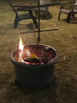 a grill with fire in it in a yard at Ataias 2 in Santa Rosa de Calamuchita