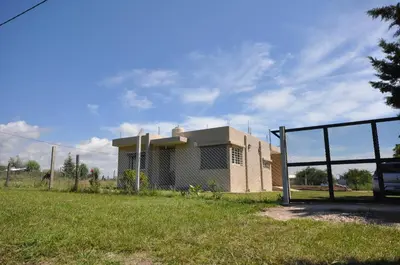 a small house in a field with a fence at pequeño refugio in Potrero de Garay