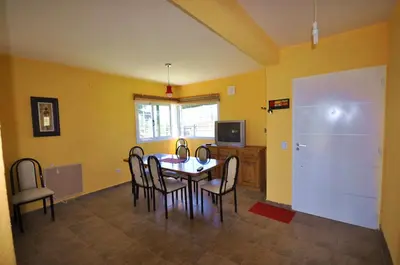 a dining room with a table and chairs and a television at pequeño refugio in Potrero de Garay