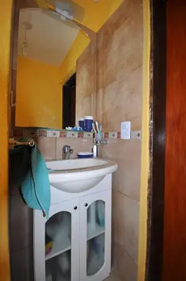a bathroom with a white sink and a mirror at pequeño refugio in Potrero de Garay