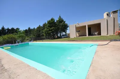 a blue swimming pool in front of a house at pequeño refugio in Potrero de Garay