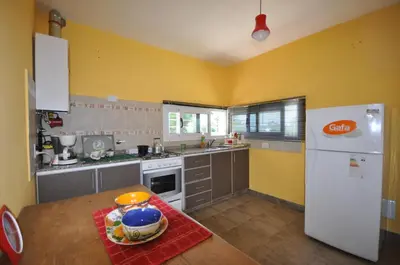 a kitchen with yellow walls and a white refrigerator at pequeño refugio in Potrero de Garay