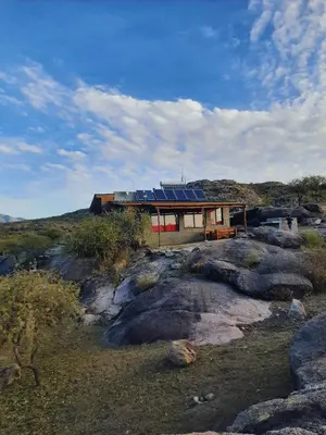 a house with solar panels on top of a hill at El Candil de las Altas Cumbres Cabañas Serranas in Nono