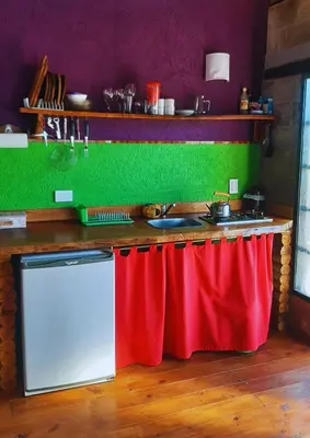 a kitchen with a red counter and a stove at El Candil de las Altas Cumbres Cabañas Serranas in Nono
