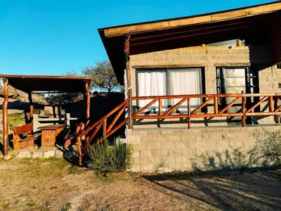 a house with a wooden porch and a deck at El Candil de las Altas Cumbres Cabañas Serranas in Nono