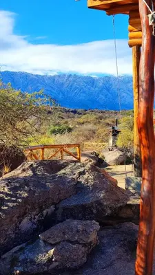 a log cabin with a view of the mountains at El Candil de las Altas Cumbres Cabañas Serranas in Nono