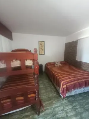 a bedroom with two beds and a cat laying on the floor at Departamentos Amanda in Santa Rosa de Calamuchita