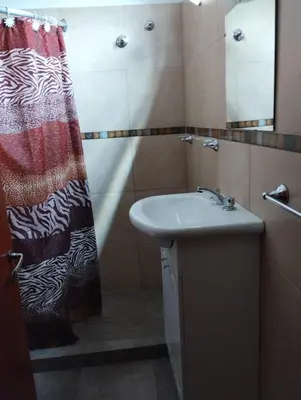 a bathroom with a sink and a shower curtain at Departamentos Amanda in Santa Rosa de Calamuchita