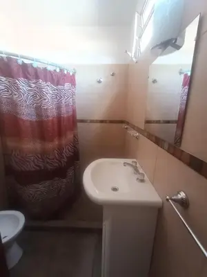 a bathroom with a sink and a shower curtain at Departamentos Amanda in Santa Rosa de Calamuchita