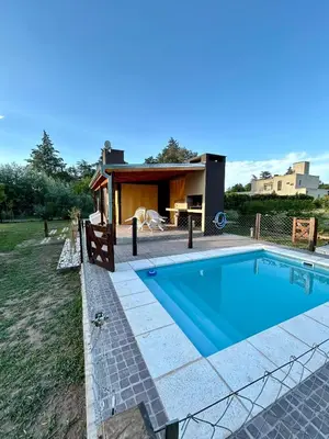 a swimming pool in front of a house at El Bravo Alojamiento in Villa Rumipal
