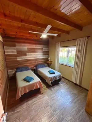 two beds in a room with wooden walls at El Bravo Alojamiento in Villa Rumipal