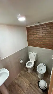 a bathroom with two toilets and a sink at El Bravo Alojamiento in Villa Rumipal