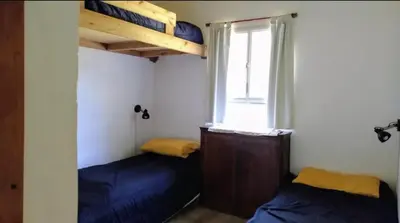 two beds in a small room with a window at La candelaria in Villa Ciudad Parque