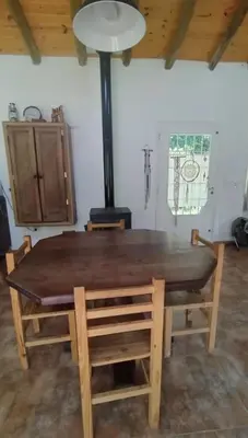 a wooden table and chairs in a room with a stove at La candelaria in Villa Ciudad Parque