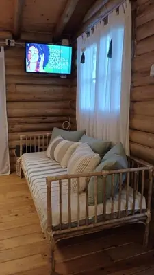 a bed in a room with a tv on a wall at Cabaña el atardecer in Villa Anizacate