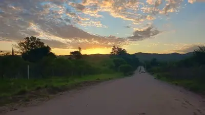 an empty road with a sunset in the background at Cabaña el atardecer in Villa Anizacate