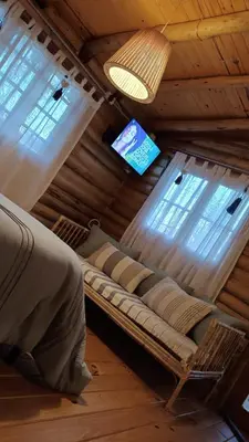 a couch in a room with a tv and windows at Cabaña el atardecer in Villa Anizacate