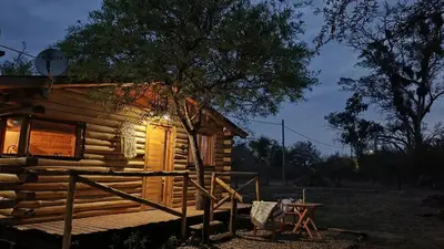 a log cabin with a table in front of it at Cabaña el atardecer in Villa Anizacate