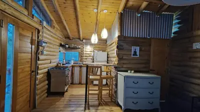 a kitchen with wooden walls and a wooden floor at Cabaña el atardecer in Villa Anizacate