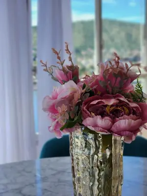 a vase filled with pink flowers sitting on a table at NUEVEAGUAS - Apartamento Panorámico sobre el Lago in Villa Carlos Paz
