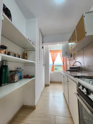 a kitchen with white cabinets and a large window at NUEVEAGUAS - Apartamento Panorámico sobre el Lago in Villa Carlos Paz