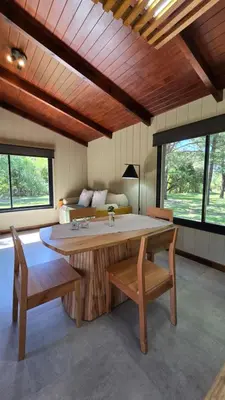 a living room with a large wooden table and benches at Cabañas del Campo - Solo Adultos in Atos Pampa