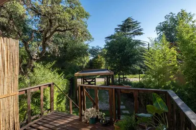 a wooden deck with a gazebo in a garden at Grace in Villa General Belgrano
