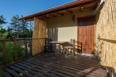 a wooden deck with a table and a wooden door at Grace in Villa General Belgrano
