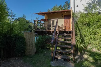a house with a wooden staircase leading to a porch at Grace in Villa General Belgrano