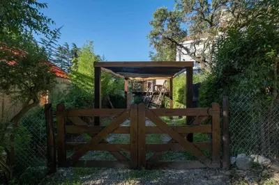 a wooden gate with a wooden shelter behind it at Grace in Villa General Belgrano