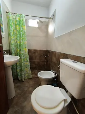 a bathroom with a toilet and a sink at El Maná in Villa Cura Brochero