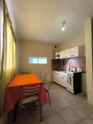 a kitchen with an orange table and chairs in a room at El Maná in Villa Cura Brochero