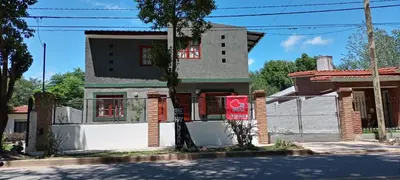 a house with a red sign in front of it at El Maná in Villa Cura Brochero