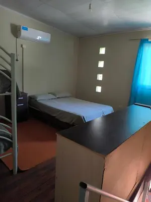 a room with two beds and a desk in it at El Maná in Villa Cura Brochero