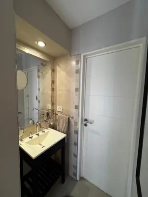 a bathroom with a sink and a shower with a mirror at Alquiler Temporario Amoblado in Cordoba