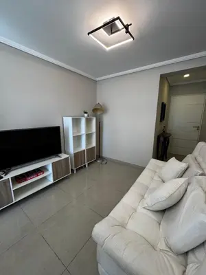 a living room with a white couch and a flat screen tv at Alquiler Temporario Amoblado in Cordoba