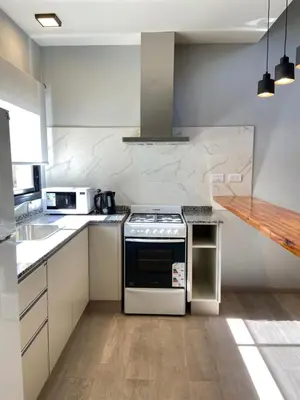 a white kitchen with a stove and a sink at Solana Apart in Mina Clavero