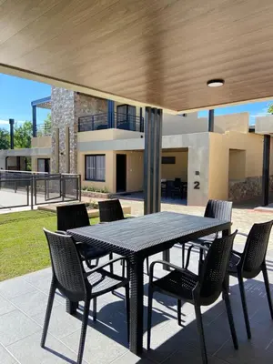 a black table and chairs in front of a house at Solana Apart in Mina Clavero