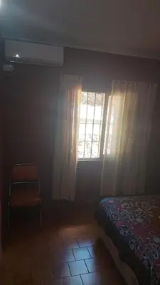 a bedroom with a bed and a window and a chair at Casa Pileta Exclusiva A 40 Mtrs Rio Y 2 Minutos Del Centro in Villa Carlos Paz