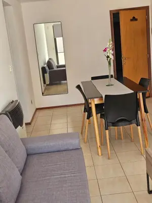 a living room with a couch and a table with chairs at Alto Parana Depto en Nueva Cordoba! in Cordoba