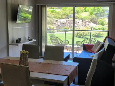 a dining room with a table and chairs and a large window at Departamento en el lago in Villa Parque Siquiman