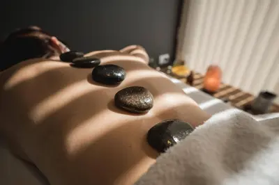 a woman laying on a bed with rocks on her back at Departamento en el lago in Villa Parque Siquiman