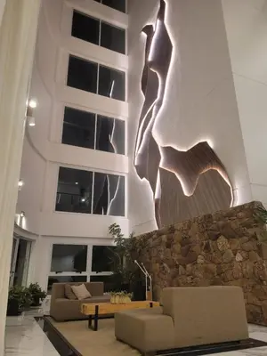 a living room with two couches and a stone wall at Departamento en el lago in Villa Parque Siquiman