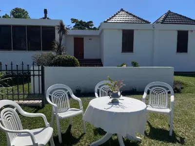 a table with four chairs and a vase on it at Casa Lac - Vista al Lago - No se aceptan grupos de jóvenes in Villa Carlos Paz
